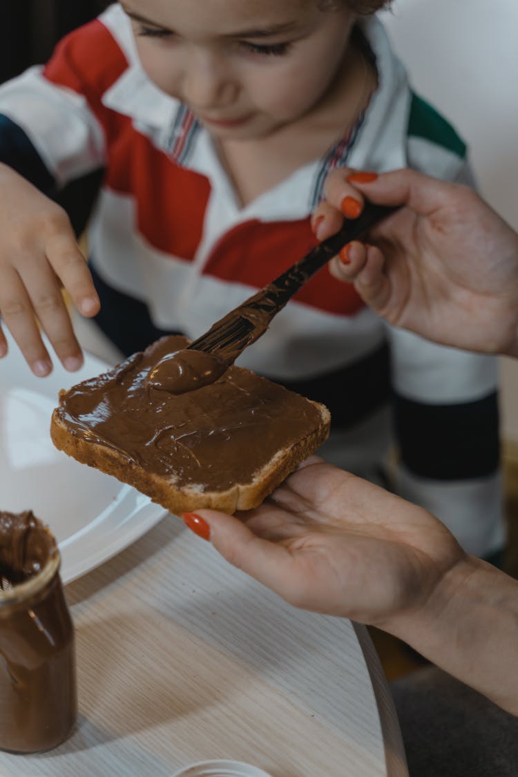 A Hand Putting Chocolate Spread On A Sandwich