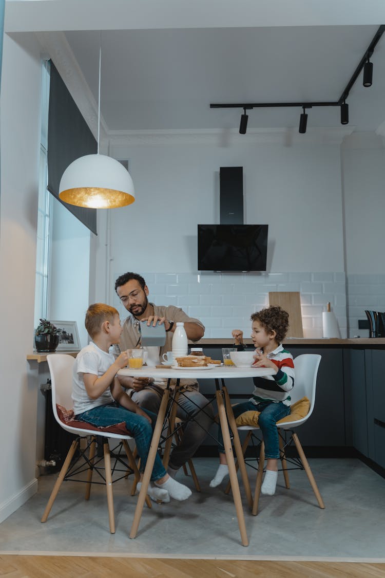 Father And Children Eating Together In The Dining Area