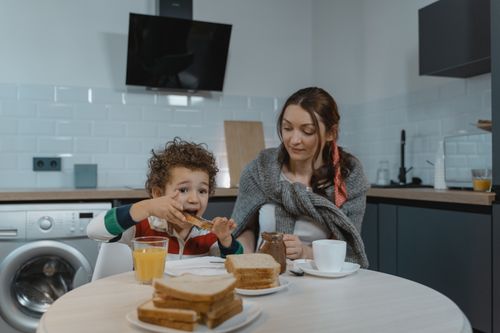 Free Mother and son bonding over breakfast in a modern kitchen setting. Stock Photo