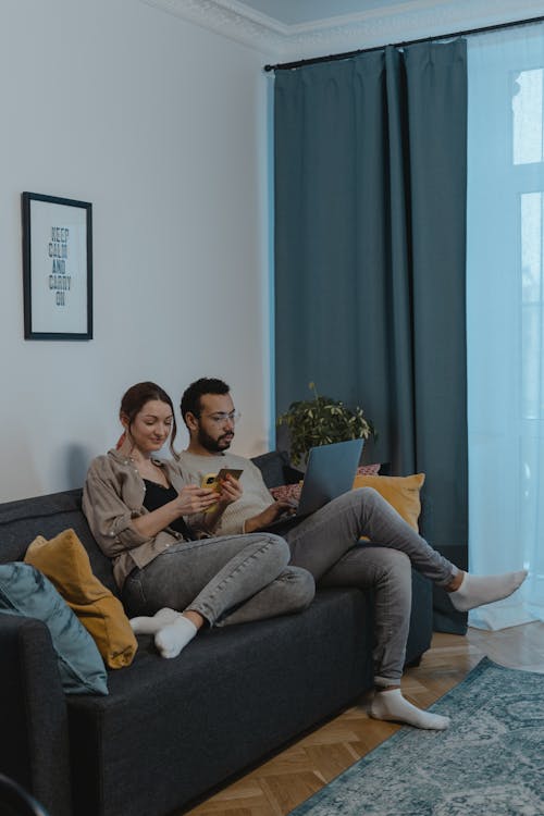 Free Man and Woman Sitting on a Sofa Stock Photo