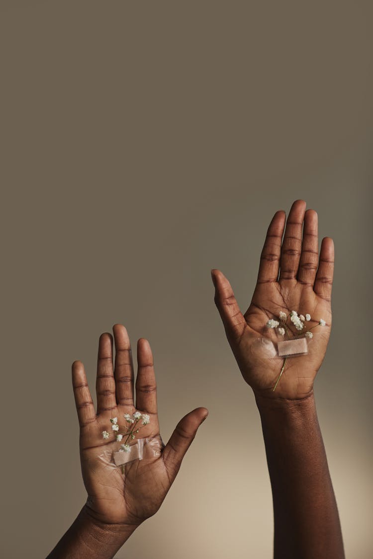 A Person With Baby's Breath Flowers Taped On Palms