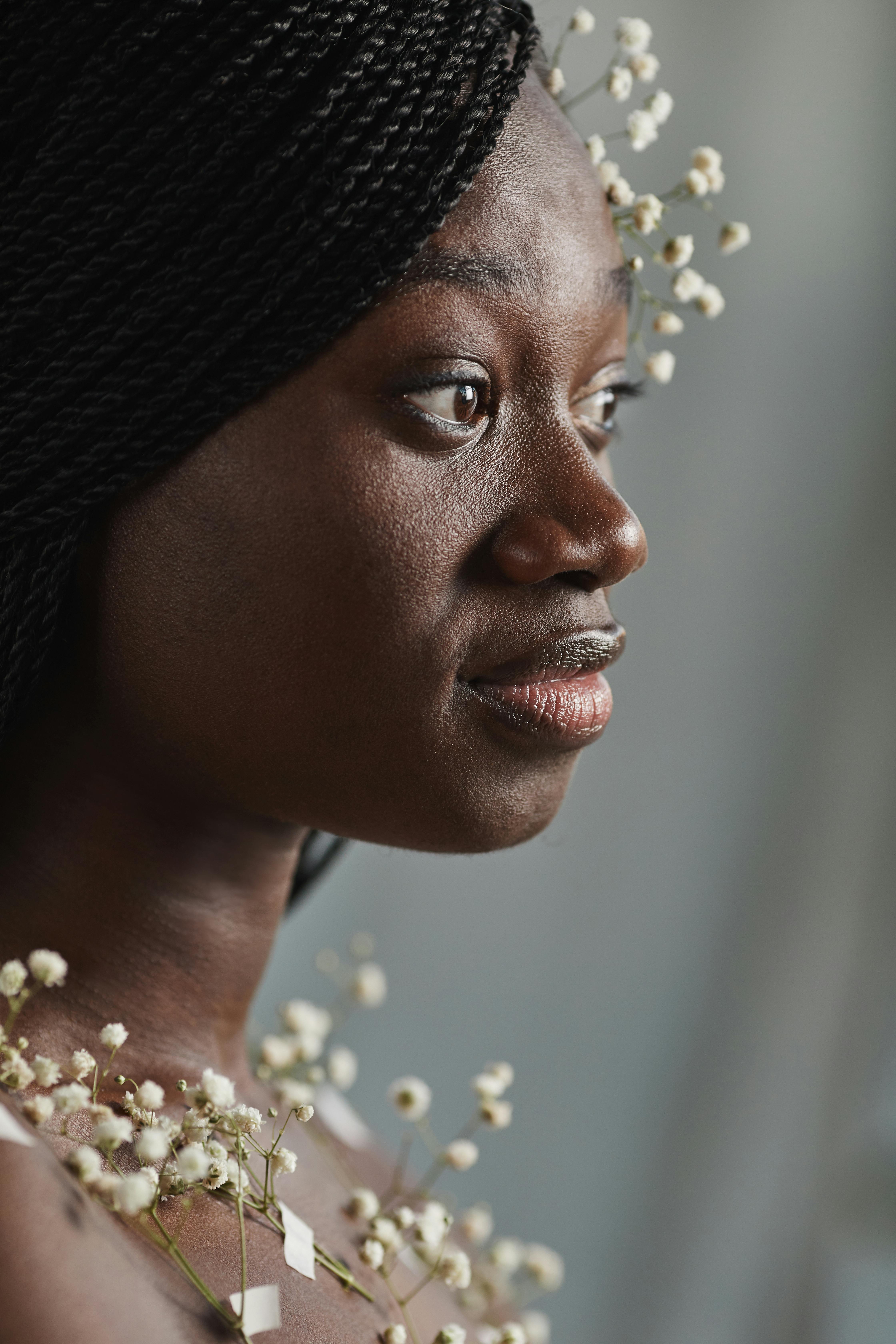 Artistic portrait of an African woman adorned with baby's breath flowers, capturing elegance and beauty.