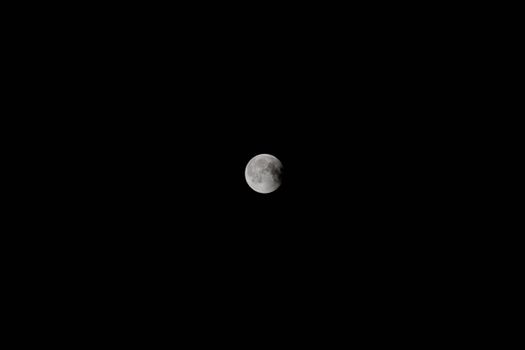A stunning full moon captured against a dark, starless night sky.