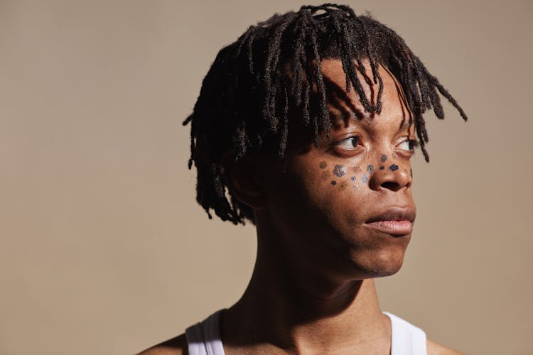 A Man With Henna Tattoo Of Flowers On Face