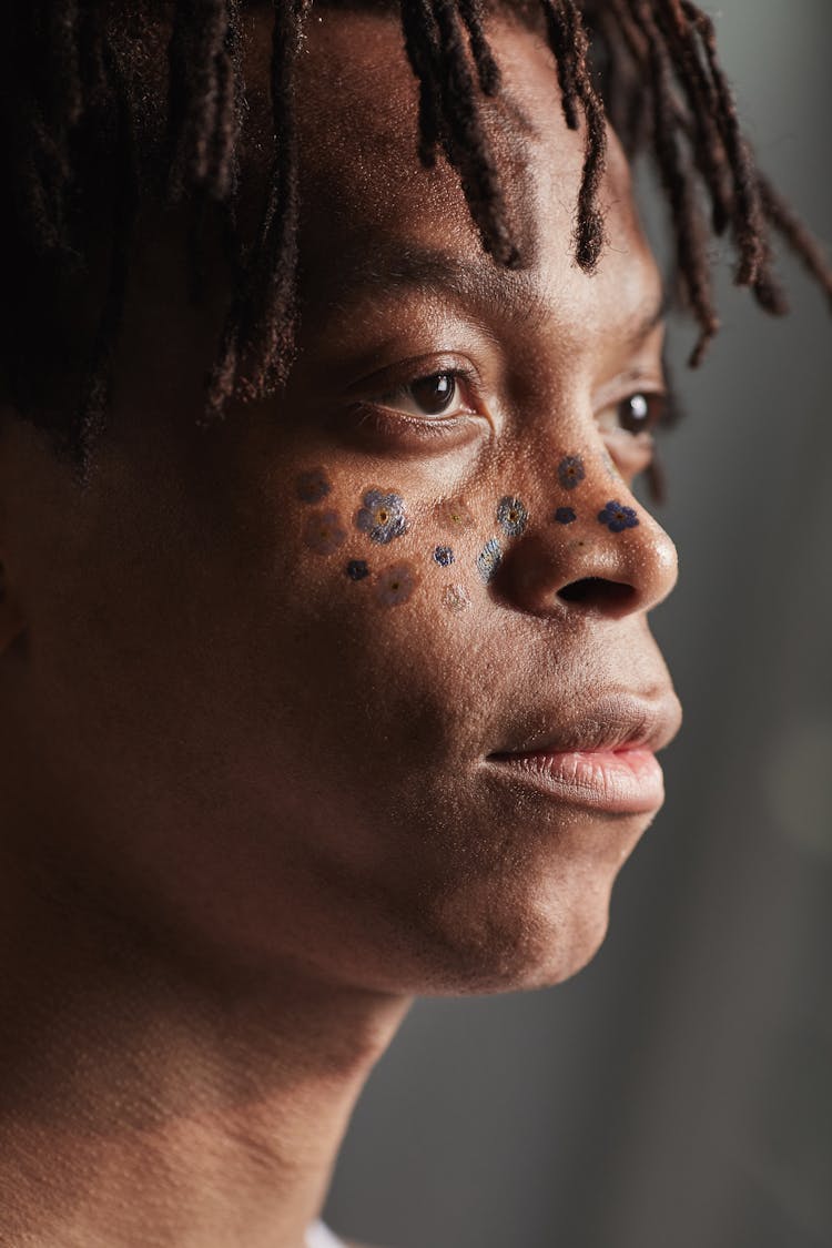 A Person With Henna Tattoo Of Flowers On Face