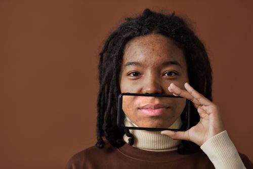 Free Innovative portrait of a woman using a phone to humorously highlight her mouth. Stock Photo