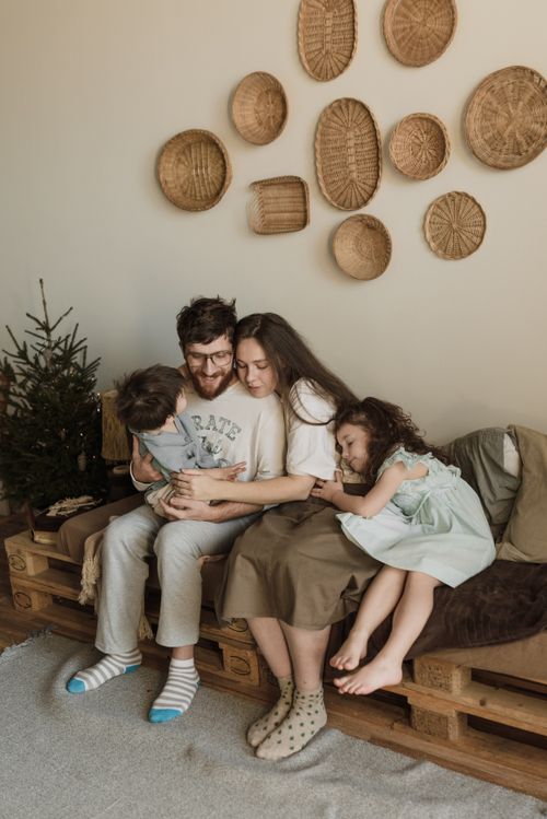 Free Family enjoying quality time together on a cozy pallet sofa indoors. Stock Photo