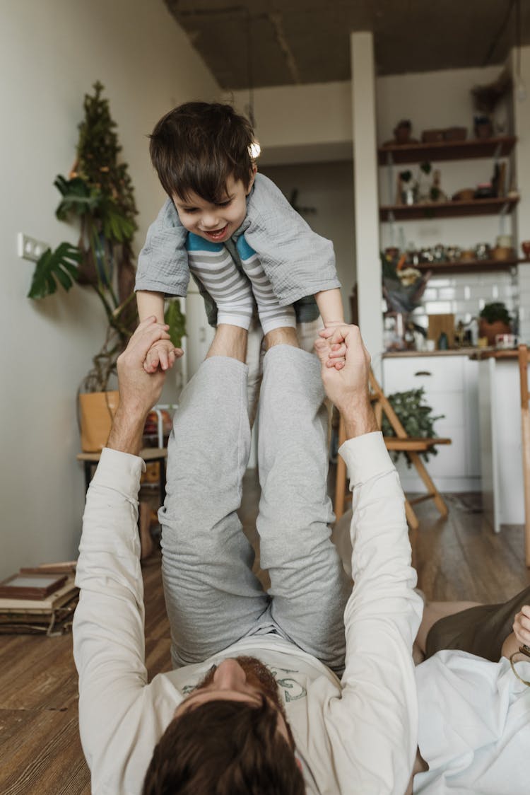 A Father Lifting Son With His Feet