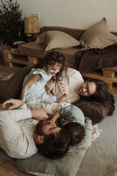 Free Happy family bonding in a cozy living room, embracing a joyful moment together. Stock Photo