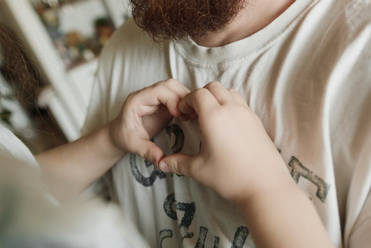 A Child Making A Heart Shape With Hands