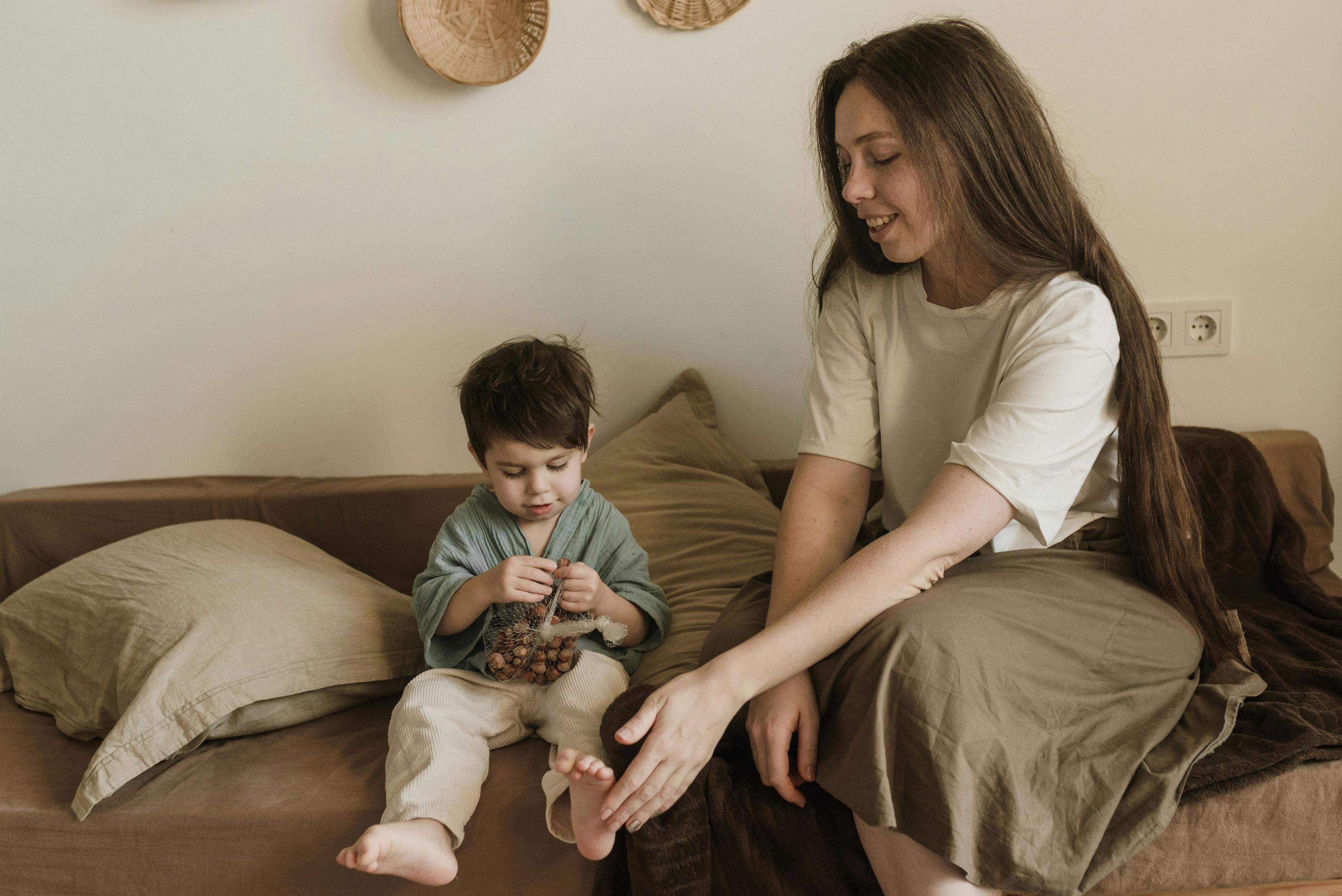 a mother sitting beside son eating a nut