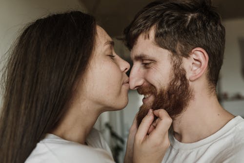 무료 화이트 크루 넥 셔츠에 남자가 여자의 뺨을 키스 스톡 사진