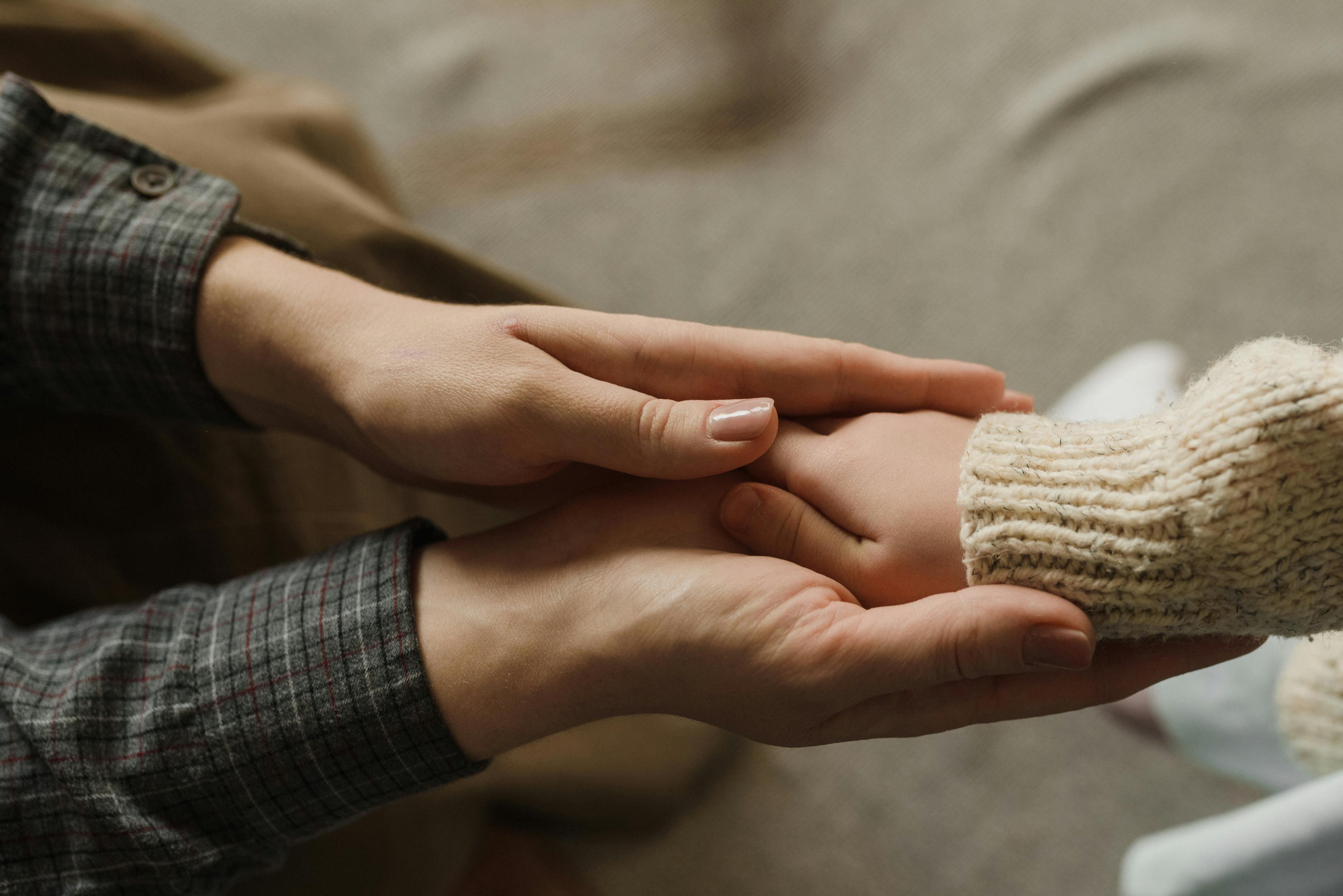 close up shot of parent holding her child s hands