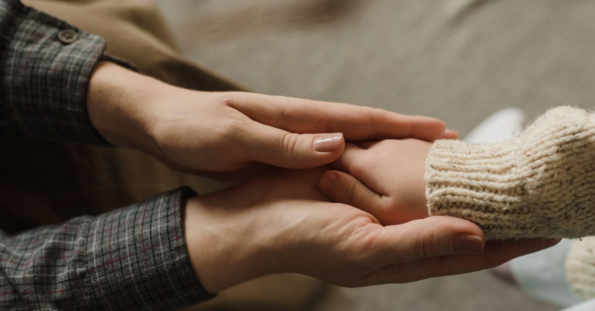 Heartwarming image showing adult and child holding hands, symbolizing affection and care.