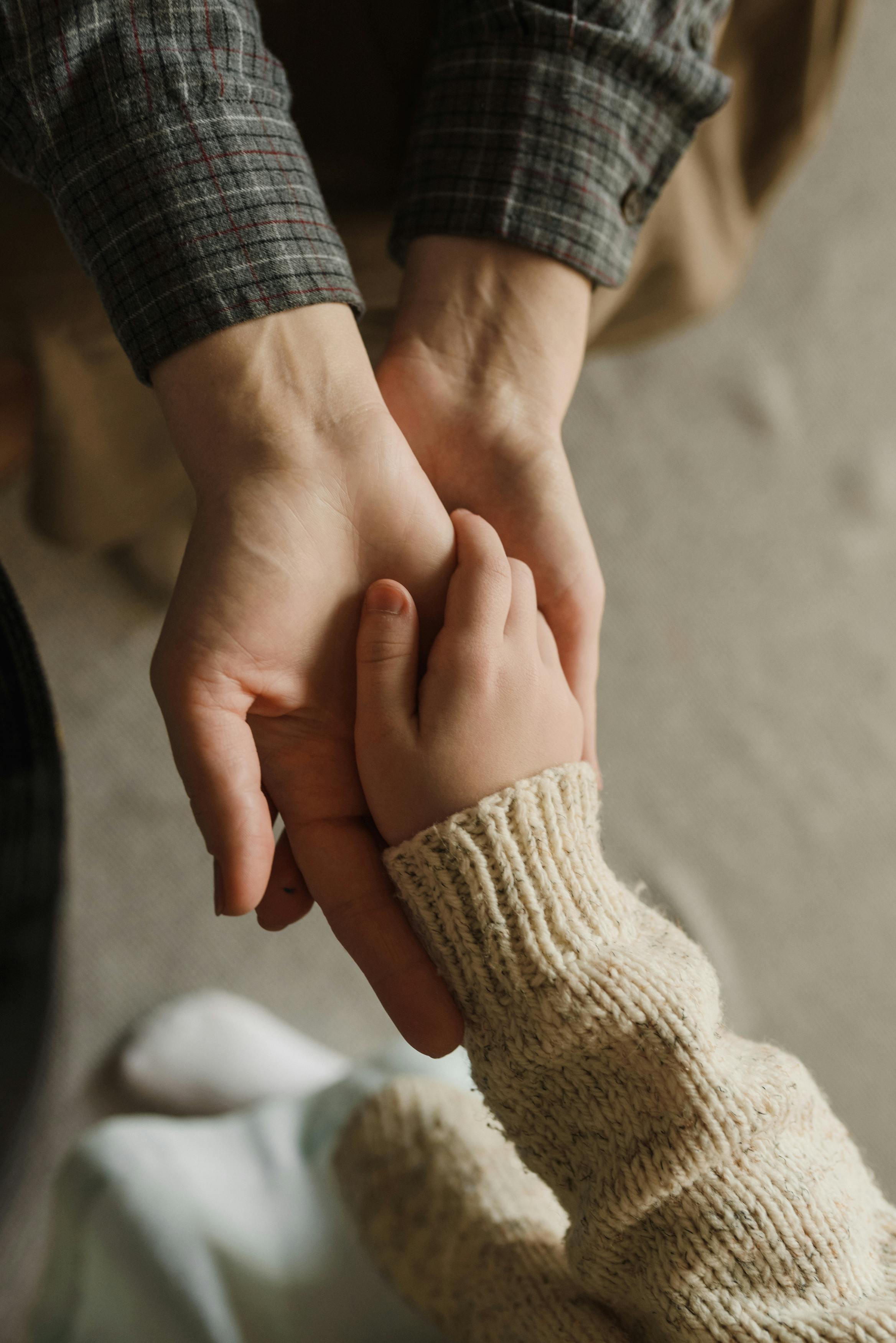 close up shot of parent holding her child s hands