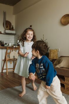 Two happy children joyfully playing inside their cozy home.