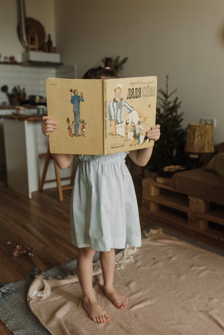 A Child Holding A Book