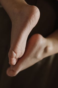 A close-up photo of bare feet with soft lighting, emphasizing texture and warmth.