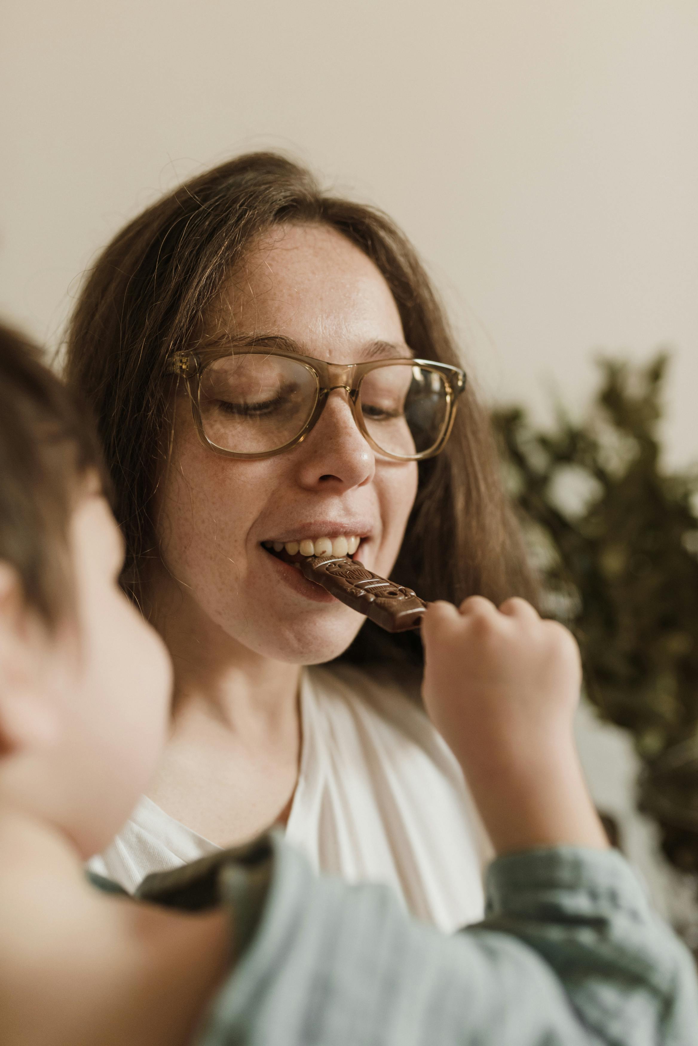 woman in white shirt eating chocolate