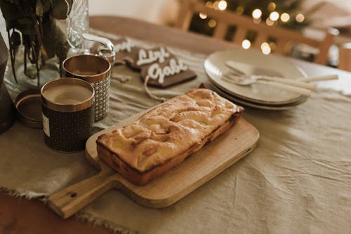 A Bread on a Wooden Chopping Board on the Wooden Table