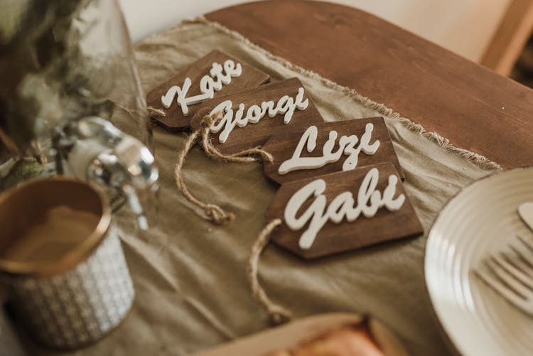 Wooden Name Tags Arranged On Table During Wedding Ceremony