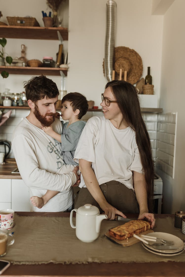  A Family Standing Beside The Table