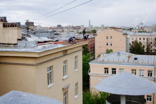 Group of Workers Working on a Rooftop in Town