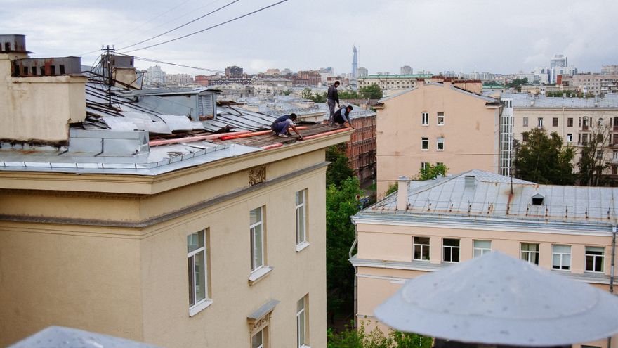 Squadra al lavoro sul lastrico solare di un condominio in area urbana