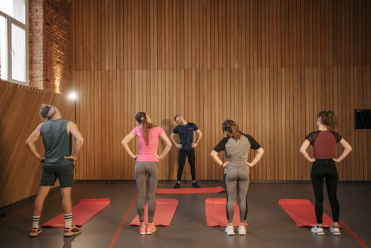 Men and women performing stretching exercises on mats in a fitness class