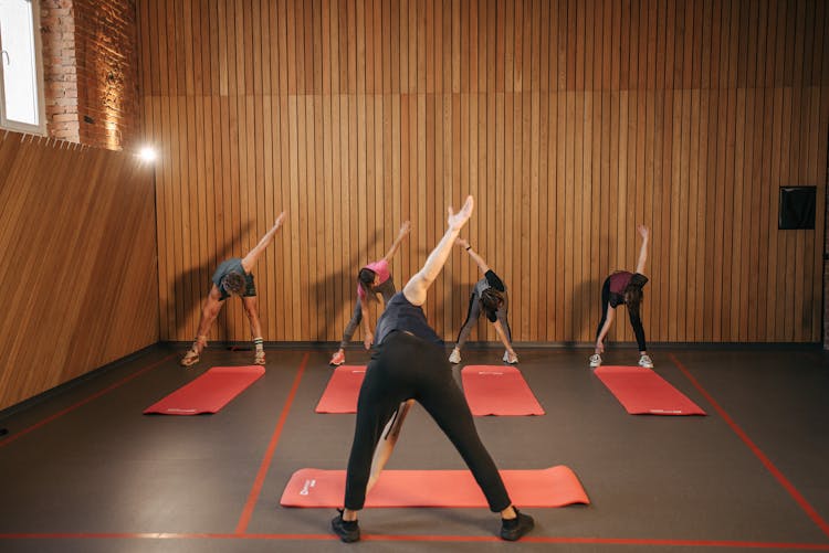 Group Of People Stretching In Yoga Studio