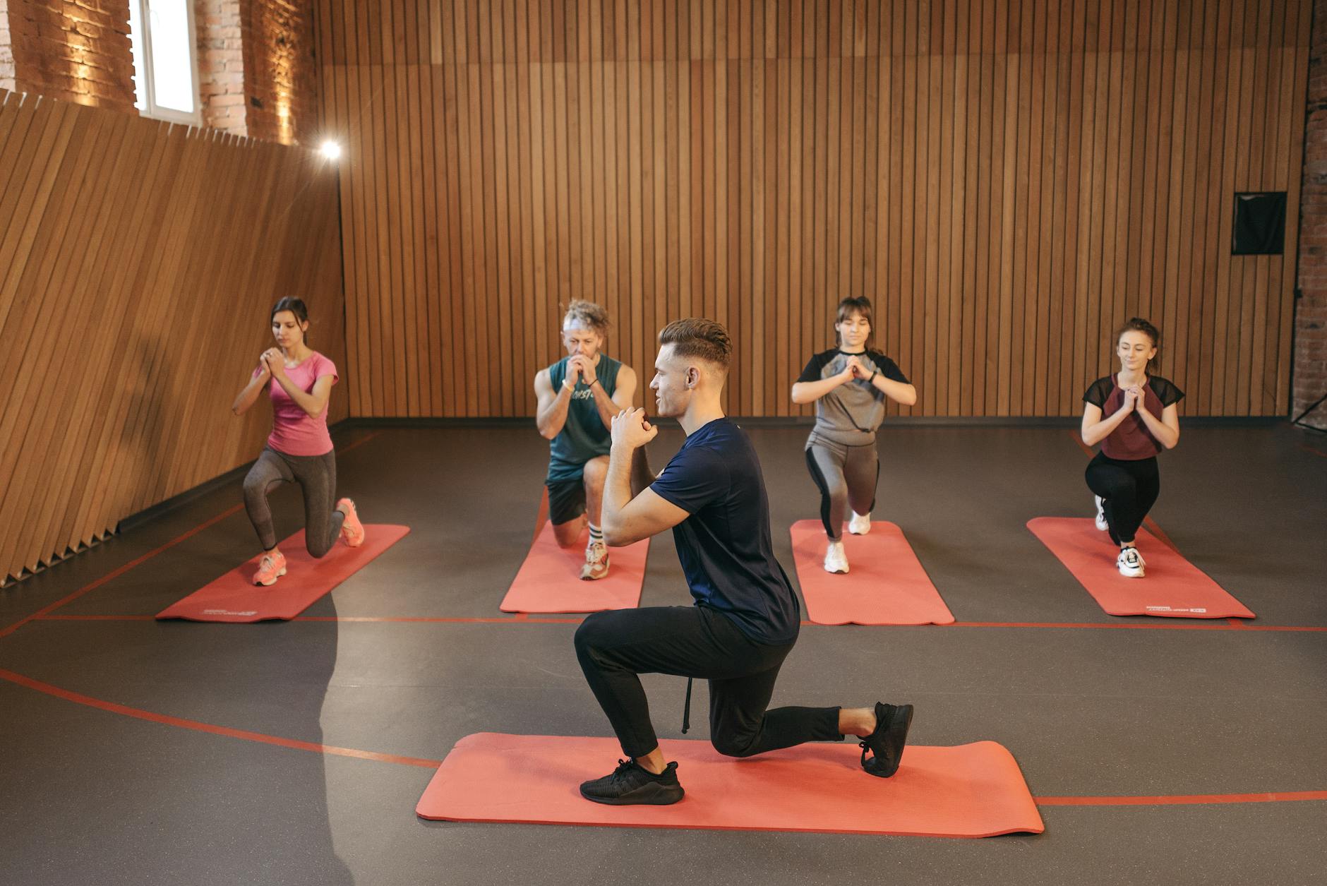 https://www.pexels.com/photo/group-of-people-stretching-in-yoga-studio-6339347/
