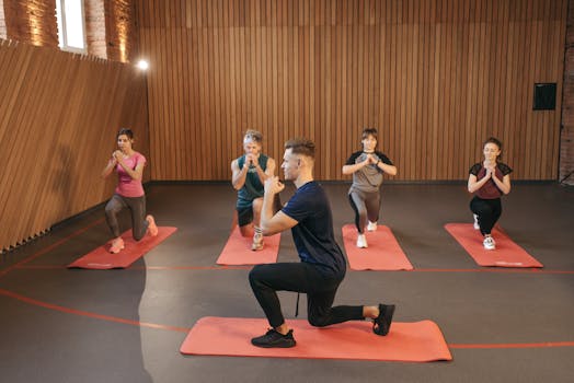A diverse group practicing fitness and yoga exercises indoors with mats.