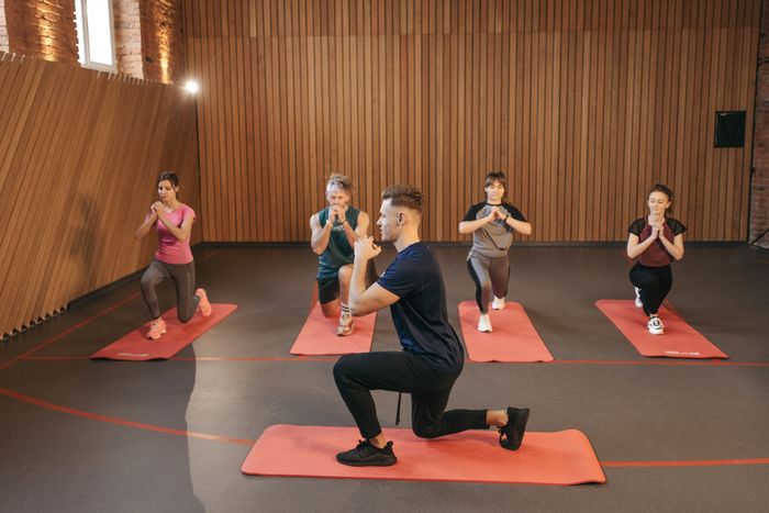 Grupo realizando estiramientos guiados en un estudio de movimiento