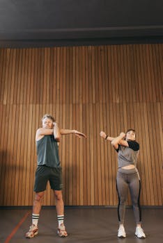 Two adults performing stretching exercises in a yoga studio for a healthy lifestyle.