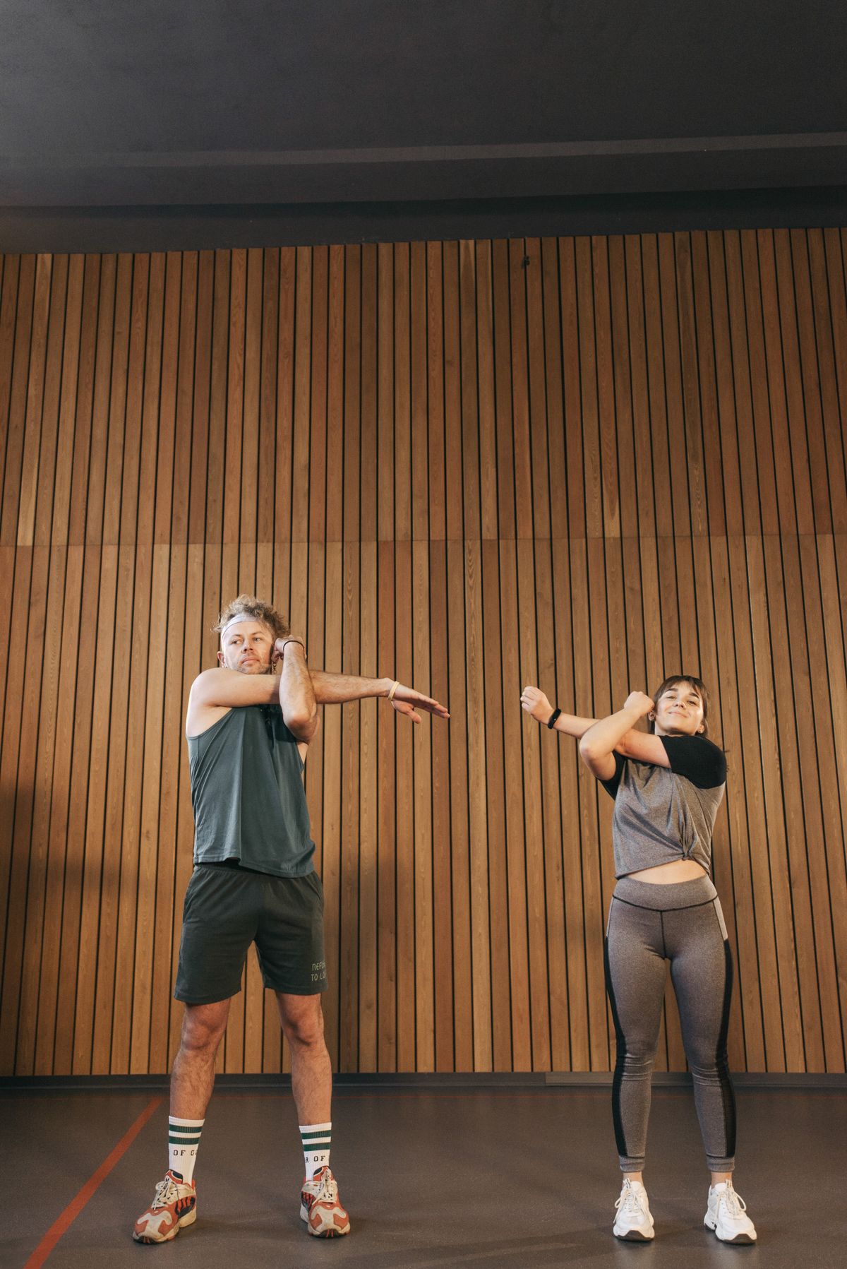 Man and woman stretching their arms during a warm-up session
