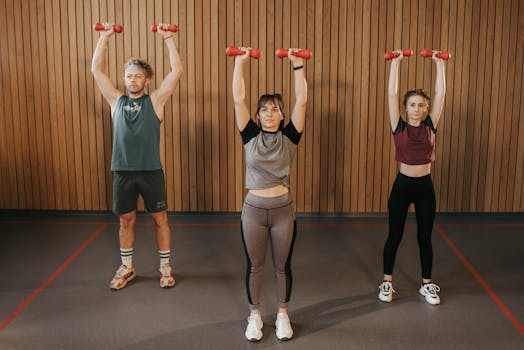 Three adults exercising with dumbbells in a gym setting, promoting fitness and healthy lifestyle.