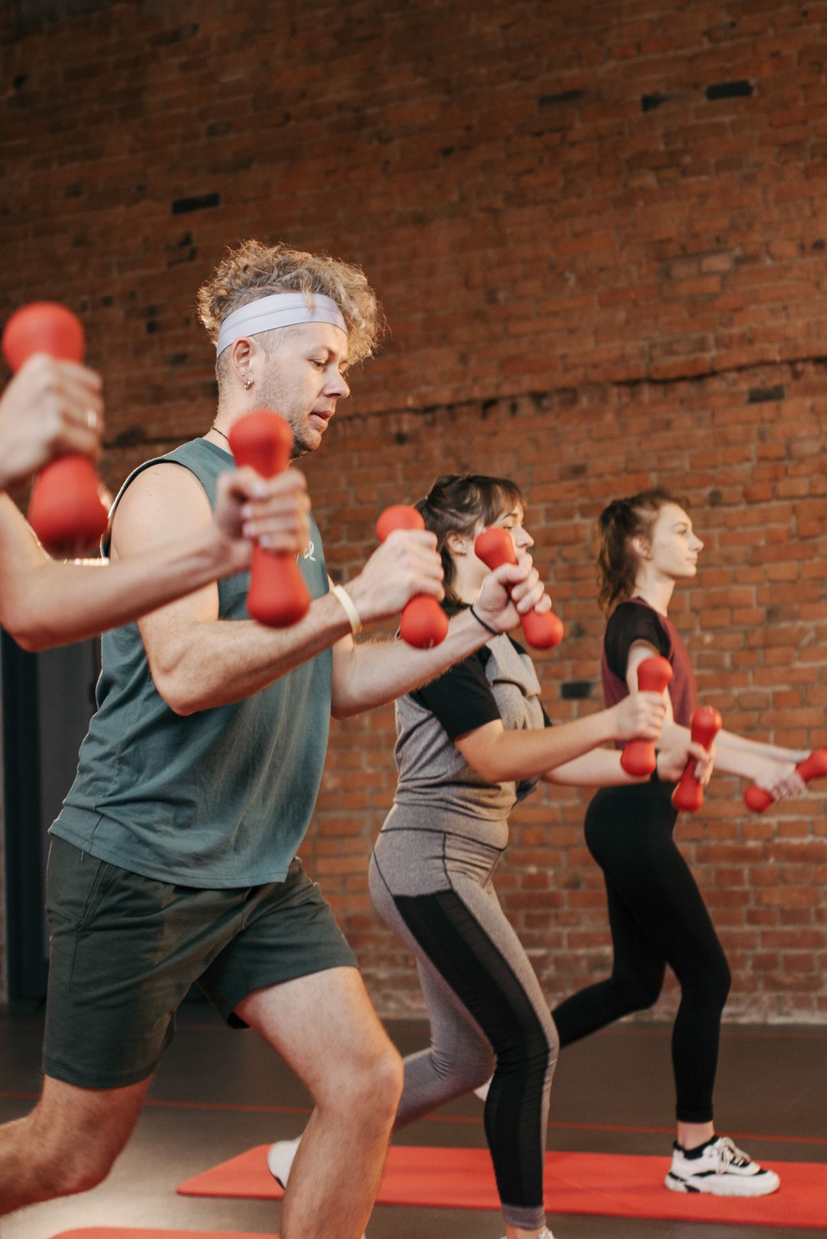 Diverse group training together with dumbbells in a gym
