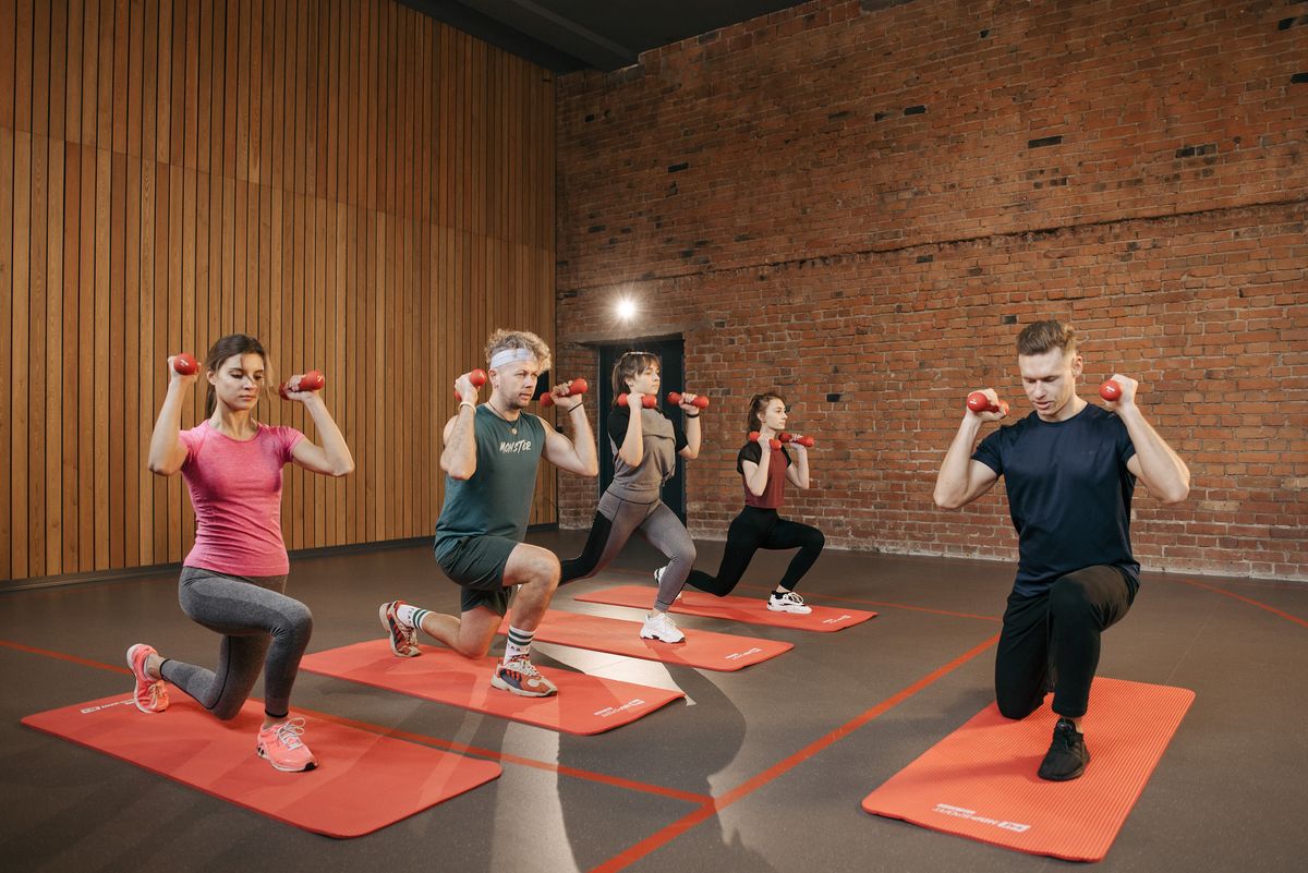 Group training together with dumbbells on exercise mats