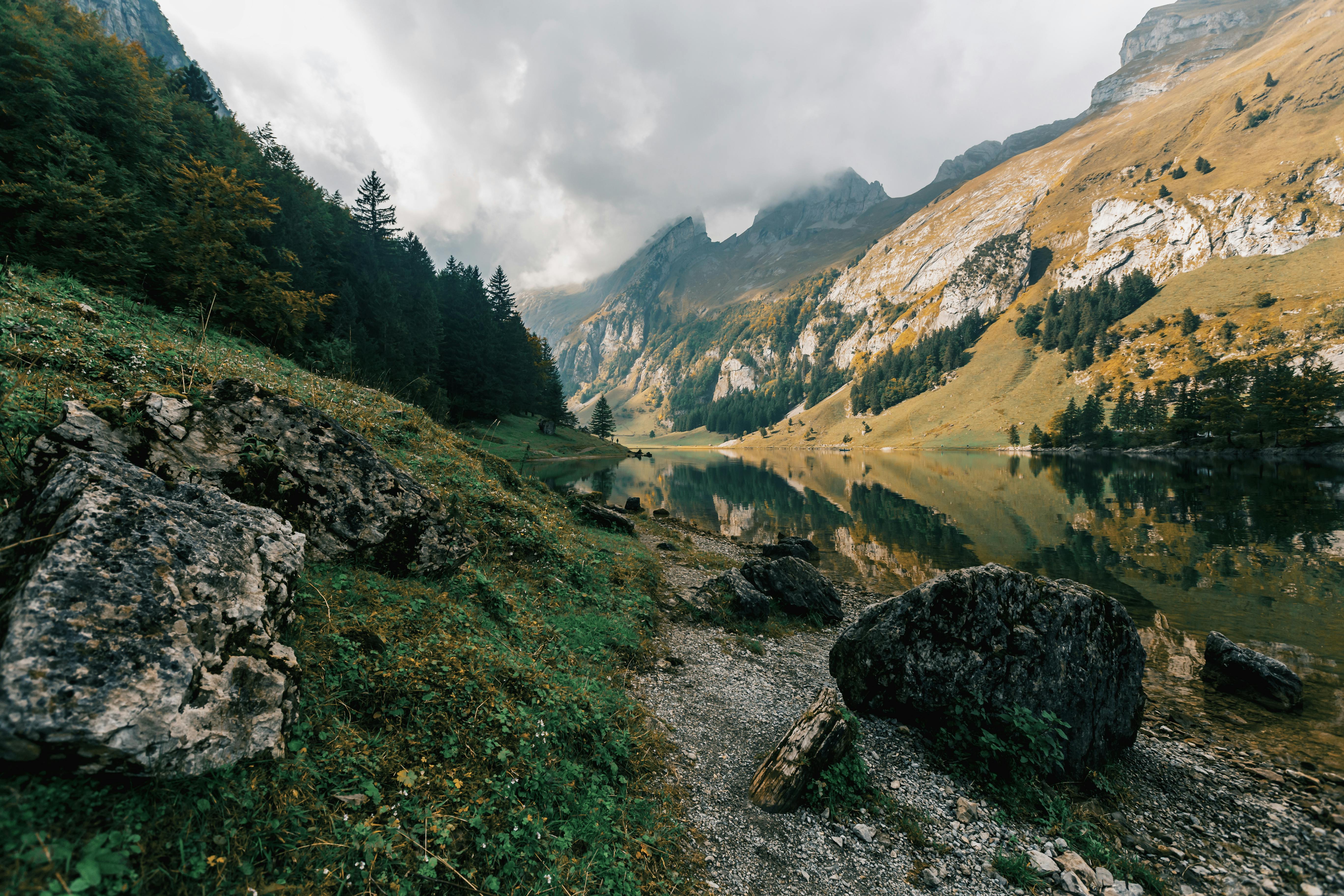 river between mountains under cloudy sky