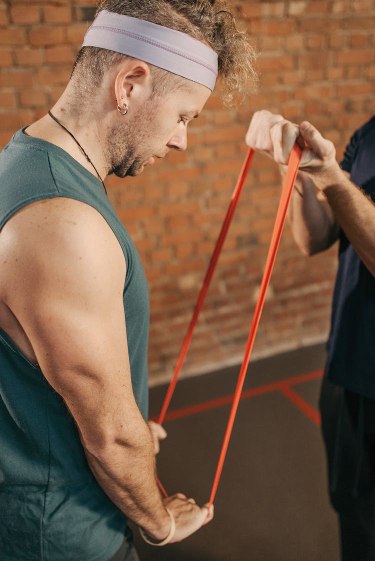 Man In Green Tank Top Doing A Resistance Band Workout