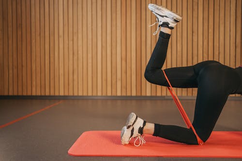Free Person in Black Leggings Doing Leg Exercise with a Resistance Band Stock Photo