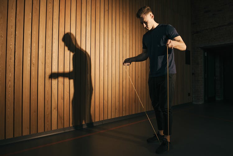 A Man In Blue Shirt Stepping On A Rope