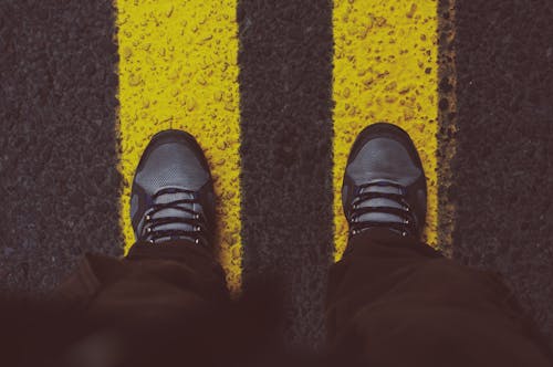 站在人行道上的灰色運動鞋的人