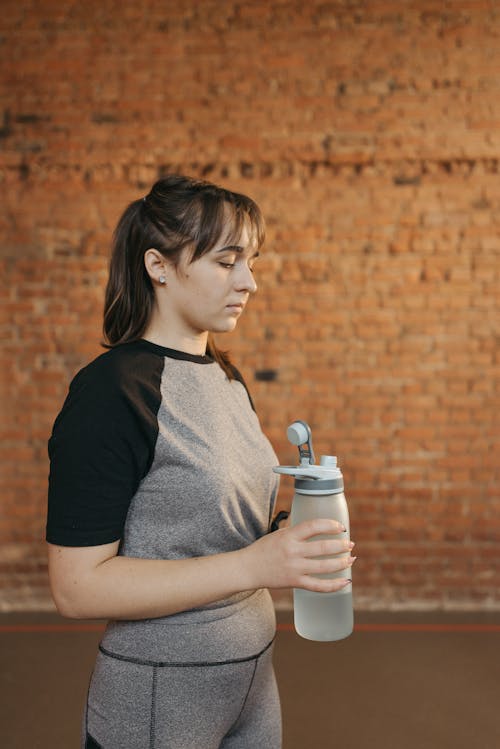 A Woman Holding a Tumbler with  Water