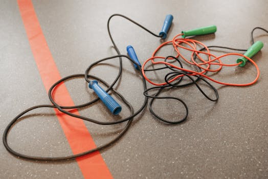 Tangled jump ropes on a gym floor highlighting fitness and exercise equipment.