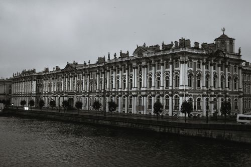 Free Majestic Winter Palace by the river under cloudy skies, showcasing baroque architecture. Stock Photo