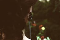 一位佩戴优雅耳环的女性特写肖像，背景自然模糊