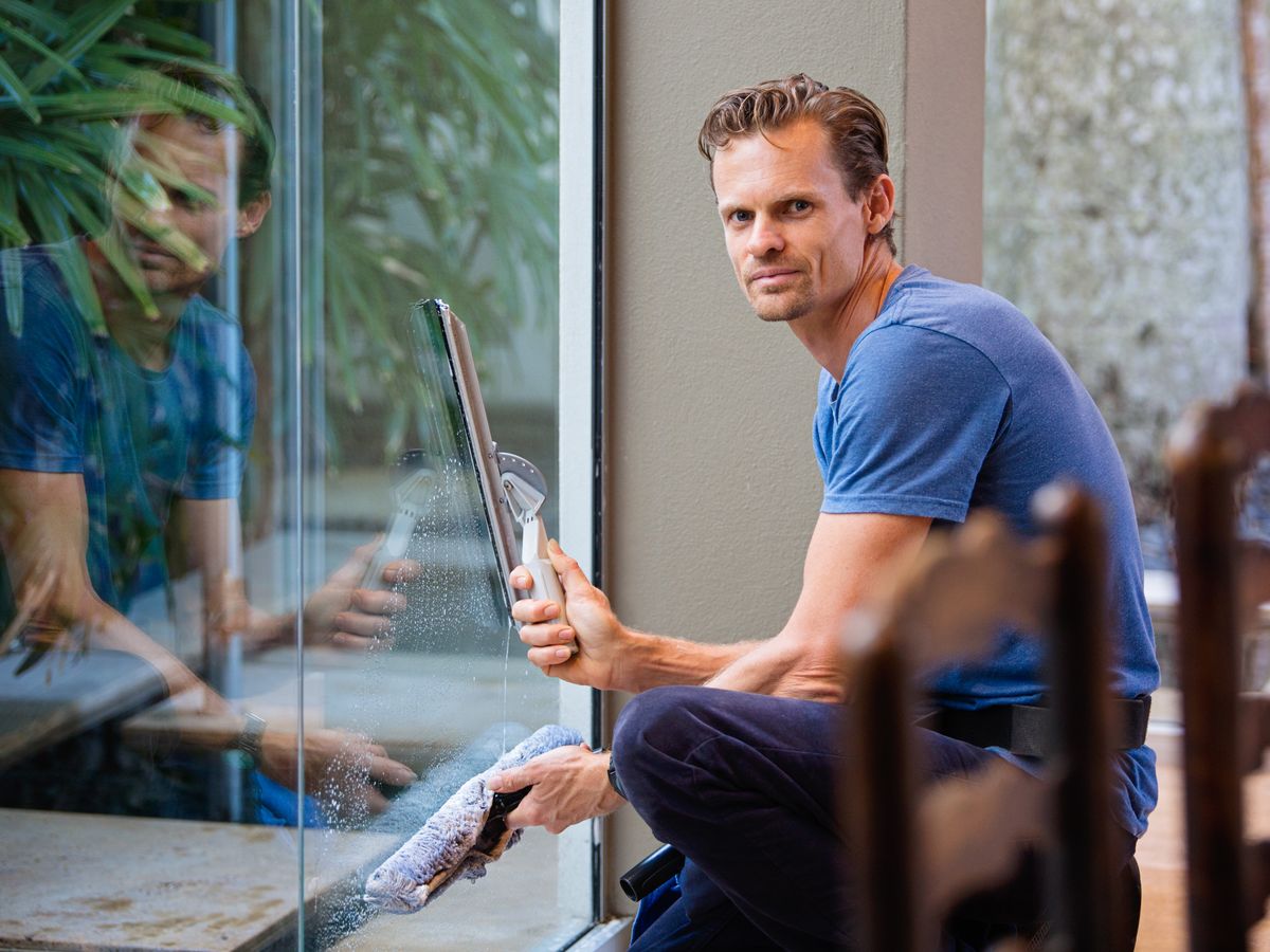 Cleaner using a squeegee on a glass window