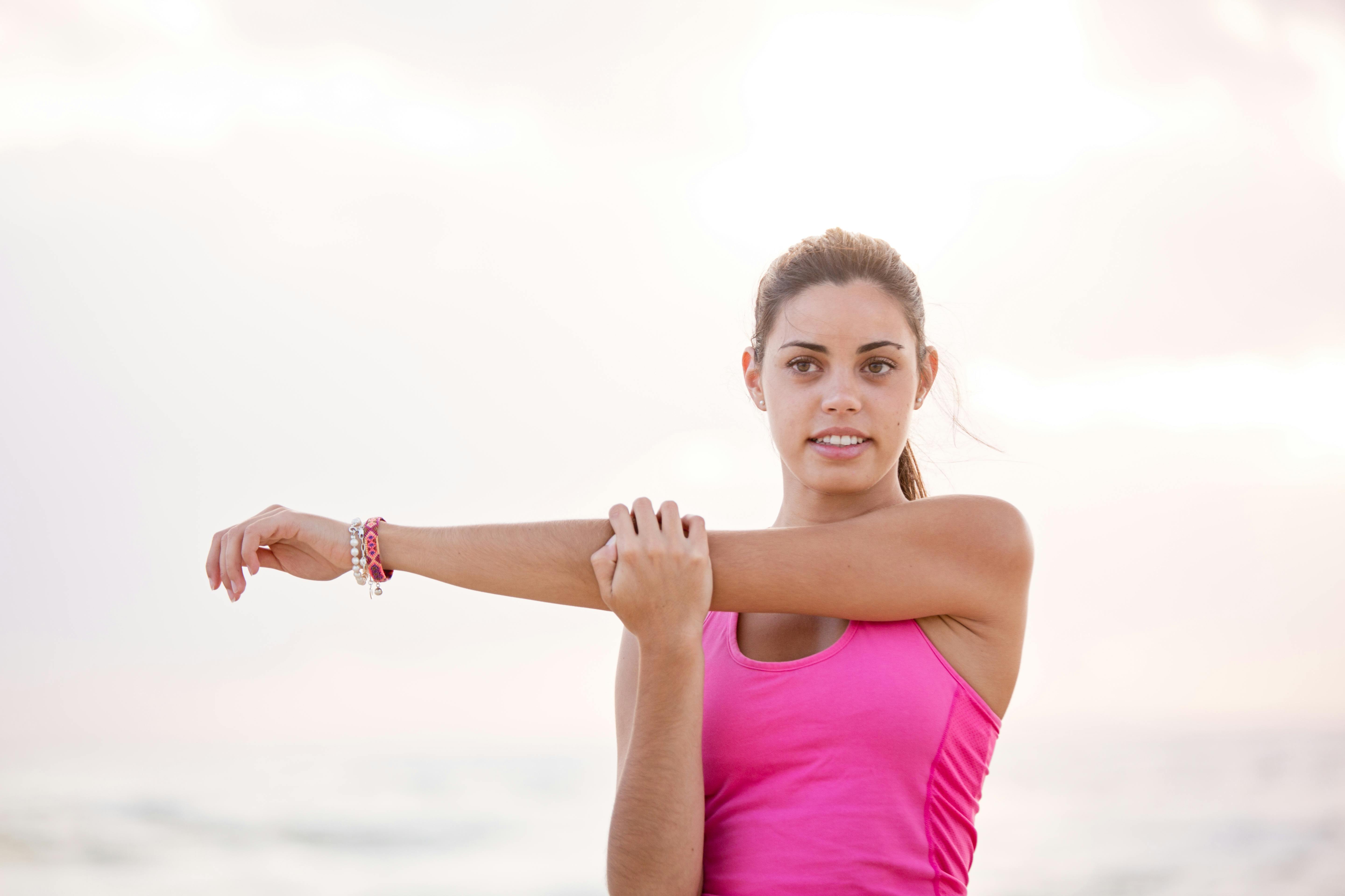 Cute Young Girl In Tank Top Stretching Out Her Arms With Her Eye