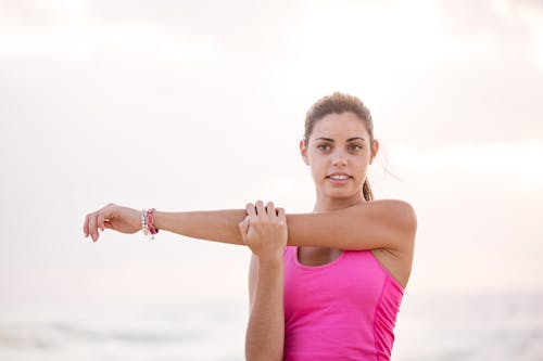 Fotografi Wanita Dengan Lengan Peregangan Tank Top Pink